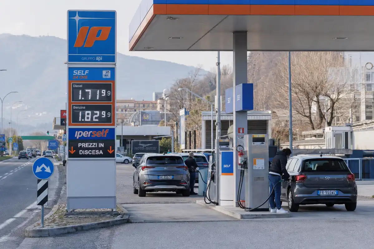 Distributore con cartello prezzi: diesel 1,719 e benzina 1,829 euro al litro, auto in rifornimento self service