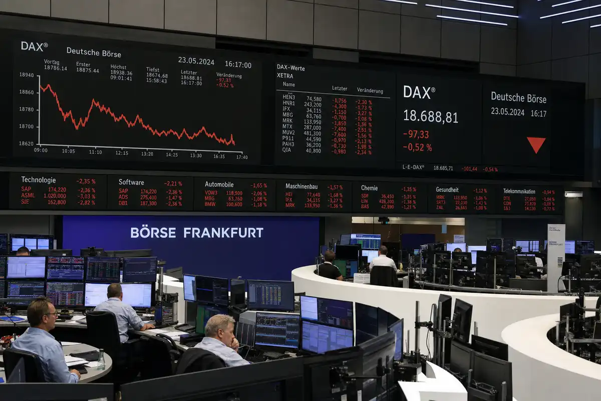 Sala trading con maxi schermi del DAX in rosso e grafico in calo alla Borsa di Francoforte