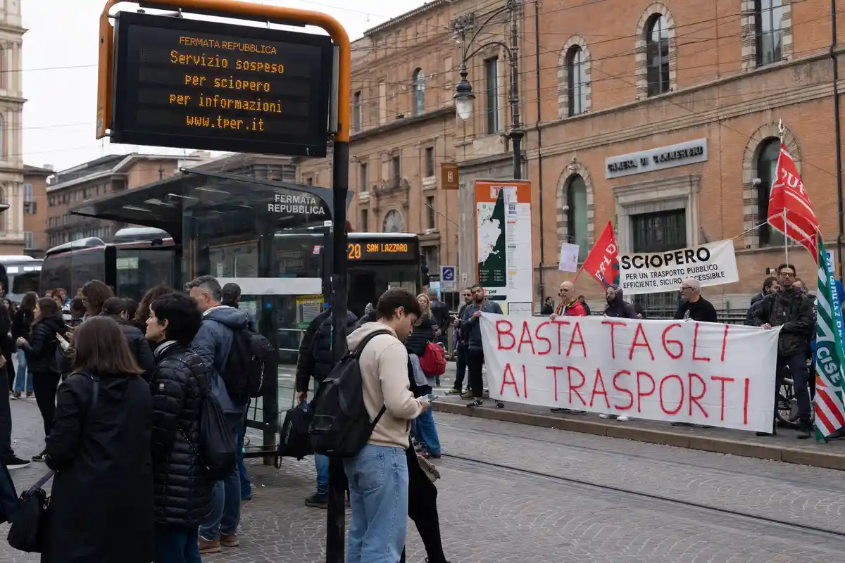 Fermata Repubblica con display "Servizio sospeso per sciopero" e manifestanti con striscione "Basta tagli ai trasporti